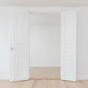 Offene weiße Flügeltür über hellem Holzboden