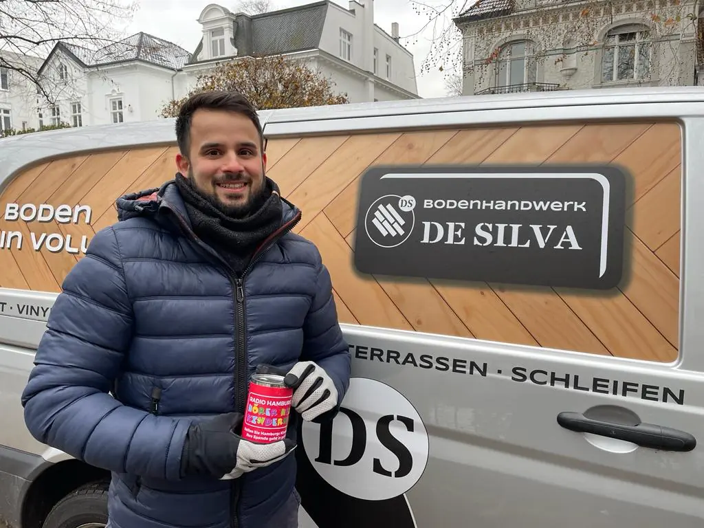 Inhaber von Bodenhandwerk De Silva vor dem Firmenwagen